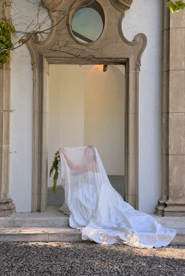 Bride framed beneath an architectural arch